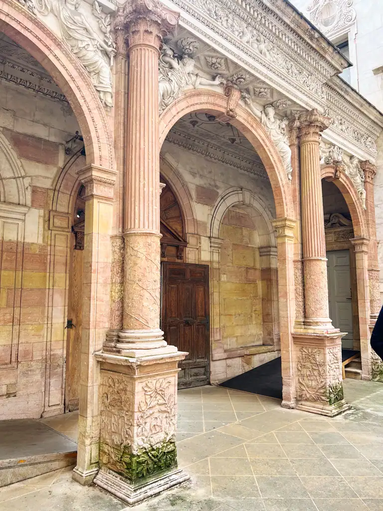 Historic pink columns and detailed architecture on Dijon's owl trail. 