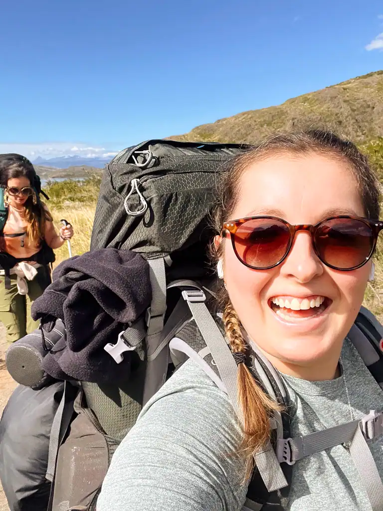 a girl takes a selfie with a second girl in the background. 