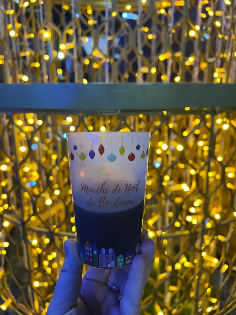 Mulled wine with lights in the background found at the Christmas markets in the best festivals around the world. 