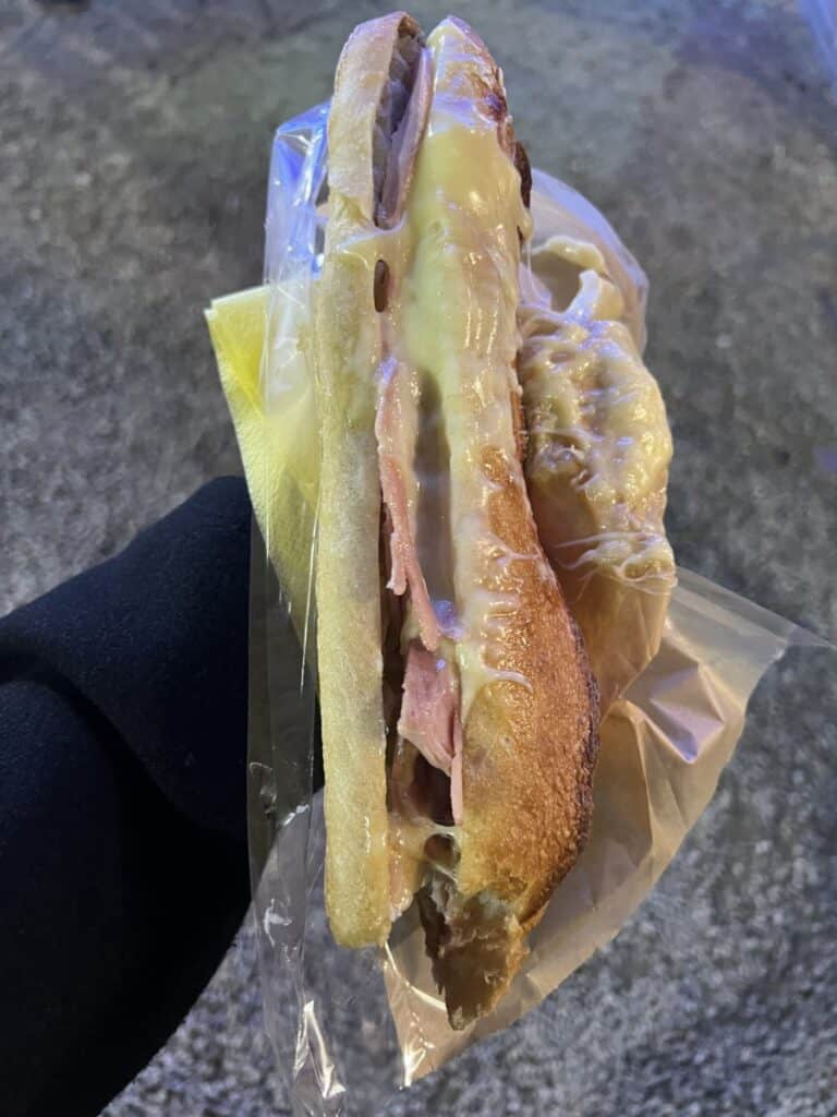 A ham sandwich with fresh fondue draped over it. 