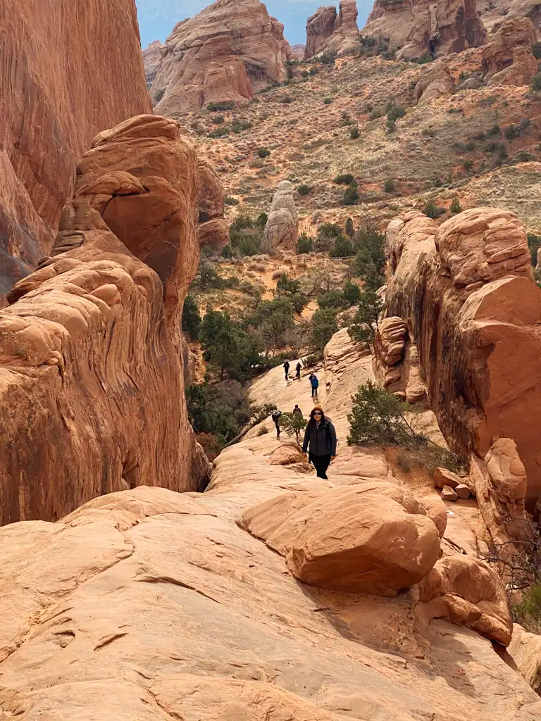 A steep rocky overlook with people in the background. 