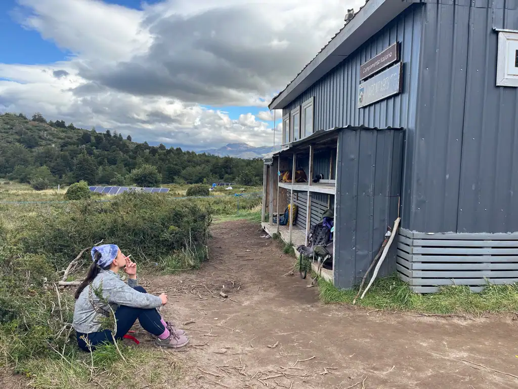 HIker smokes outside of Italiano refugio on day 3 of the w trek in Patagonia. 