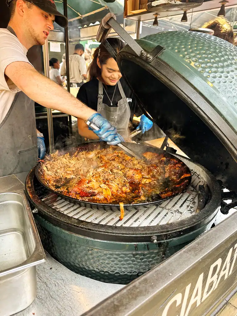 A close up of a giant vat of pork at borough market. 