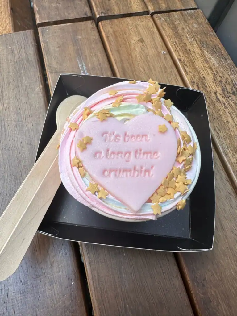 A close up of a taylor swift themed apple crumble with a heart that says "its been a long time crumbin"