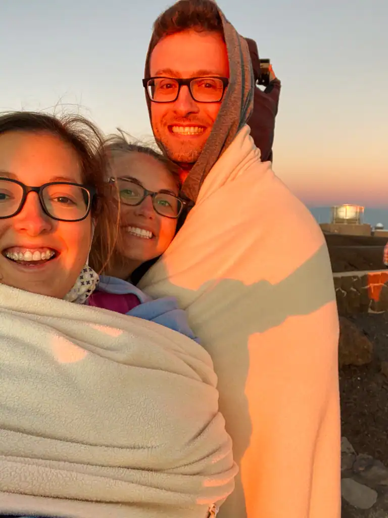 3 friends wrapped in blankets at sunrise. 