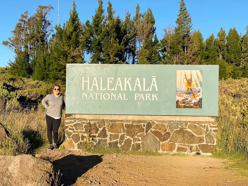 Girl standing at the Haleakala National Park visitor sign. 