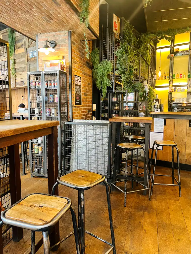 The indoors of one of the best bars in Lyon with stools adn plants adn wood features