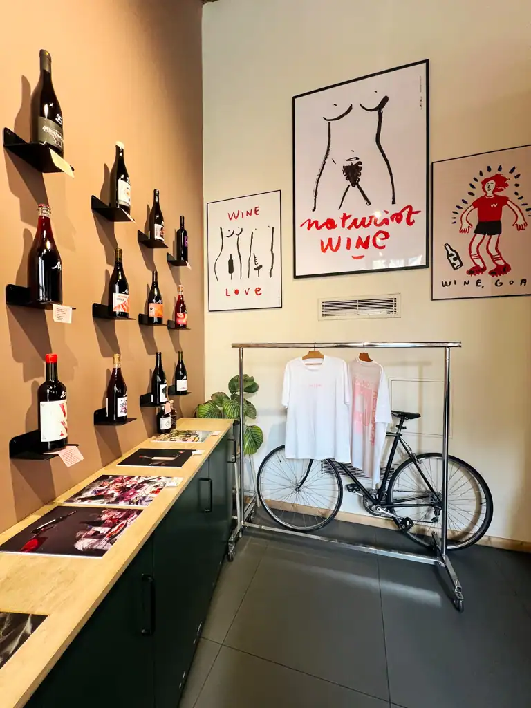 in one on the best bars in lyon you see a wall with wine, a bike, t shirts on a rack and art pieces on the wall
