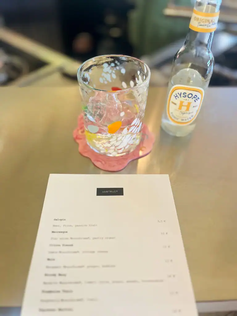 A clear cocktail glass and menu at Abstract one of the best bars in Lyon.