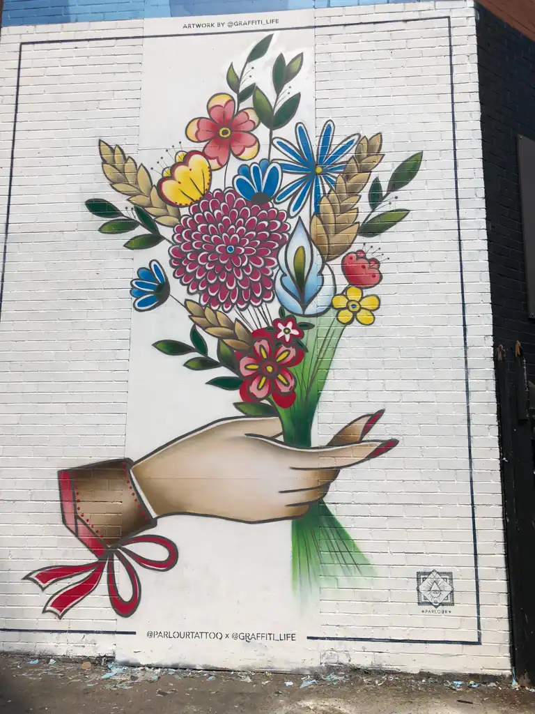 A large painting of flowers on a brick wall in London.