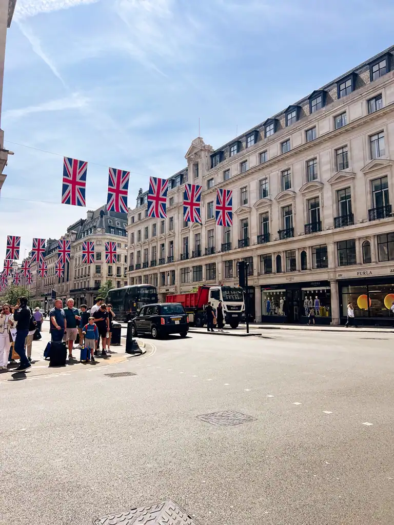 the shopping streets in covent garden, with union jacks flags hanging between buildings. 