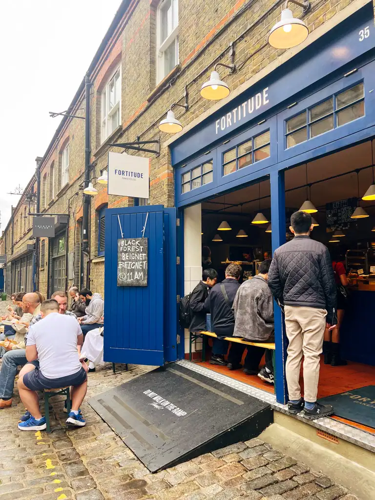 people lined up outside of the blue Fortitude bakehouse facade. 