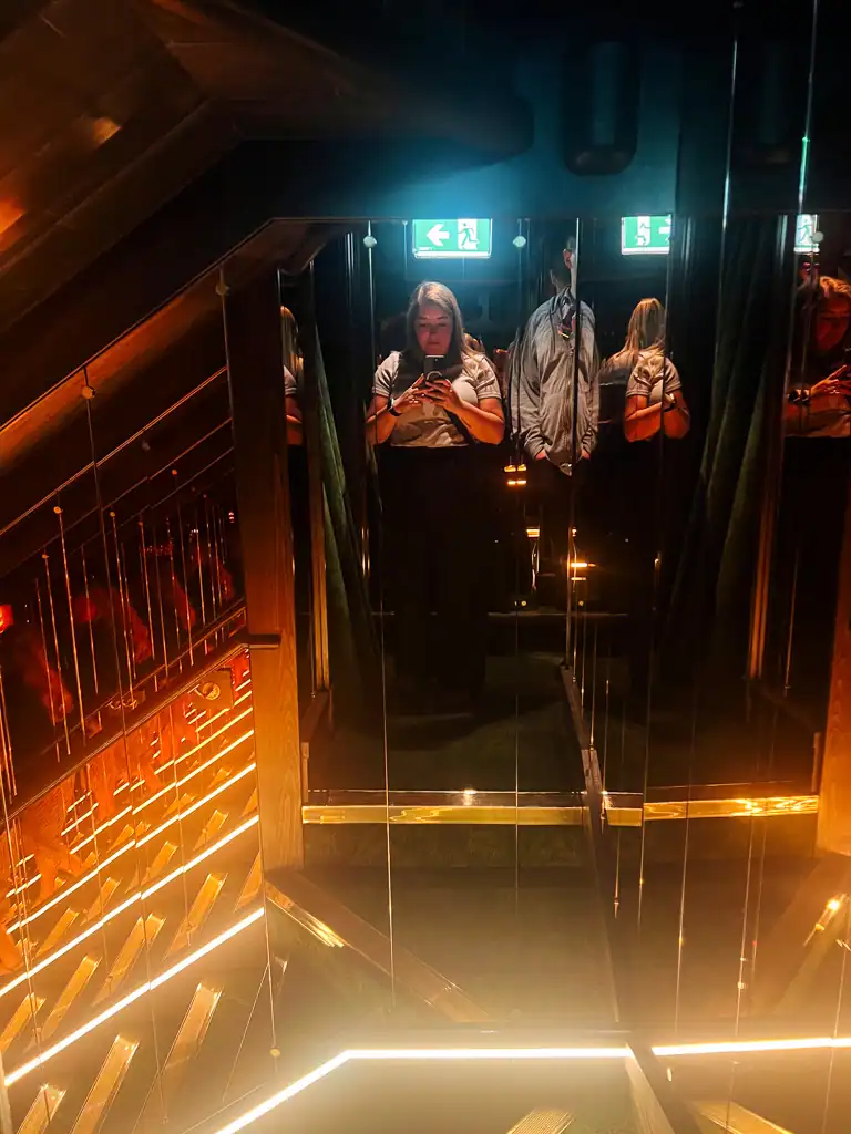 A woman pictured in the mirrored walkway at Gymkhana.