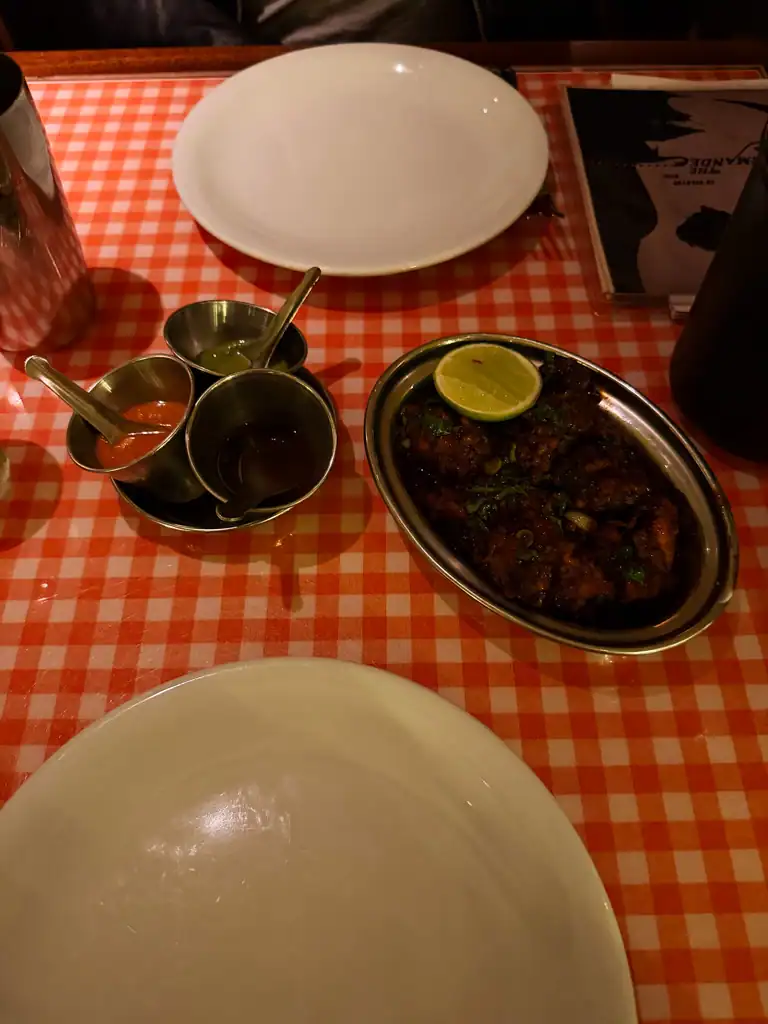 two dishes and two plates served on a red checkered table cloth.