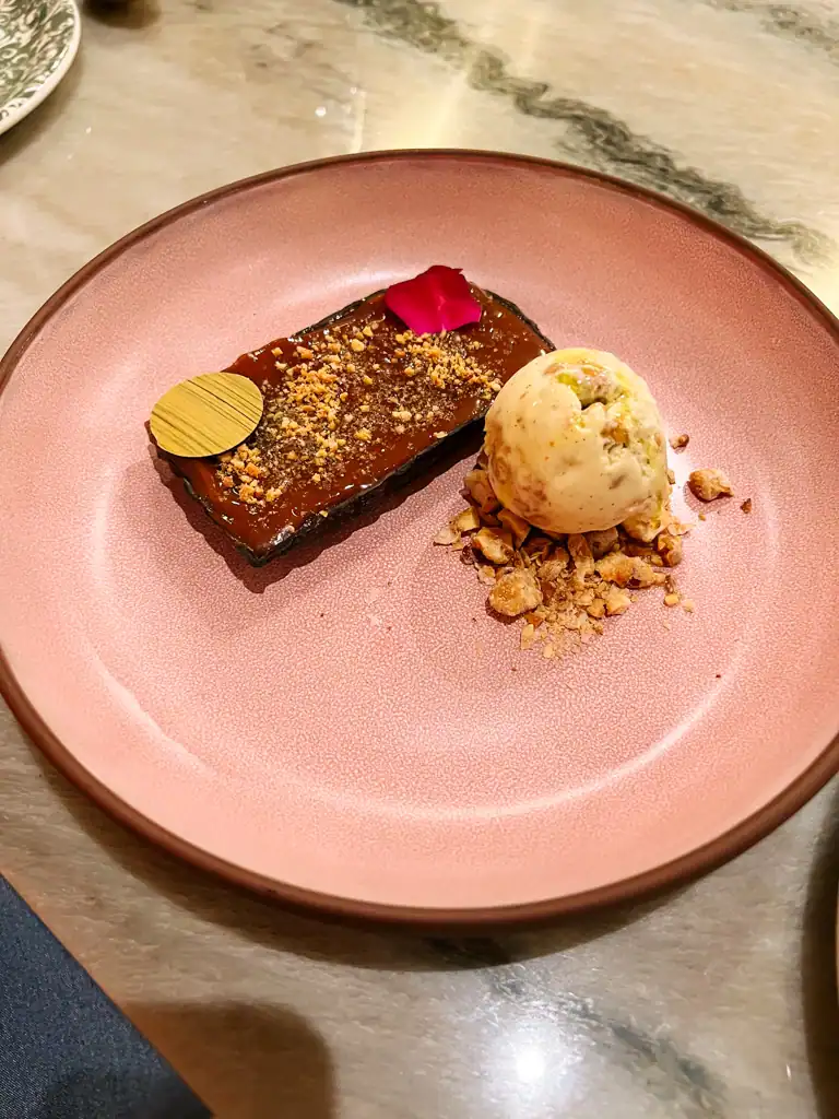 a large pink plate with a chocolate tart and ice cream on it at Kann. 