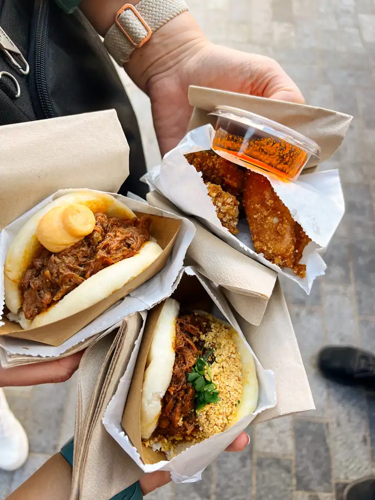 a close up of 2 bao buns and fried chicken with a red sauce from borough market. 