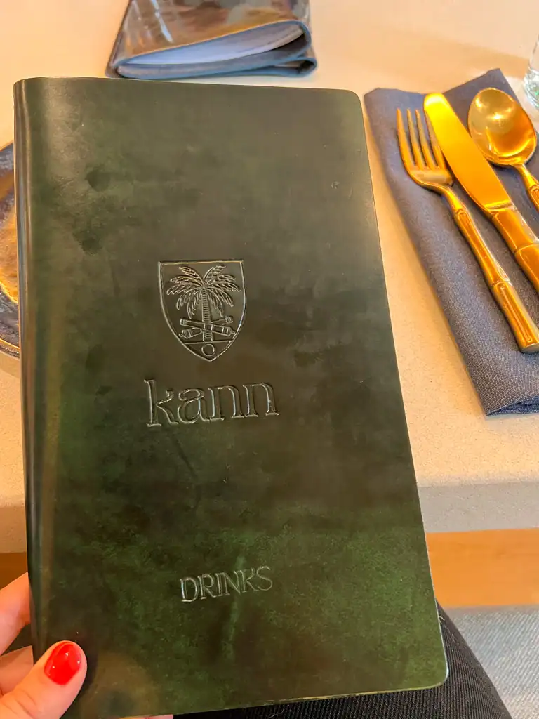 The dark blue/green, leather Kann restaurant menu. 
