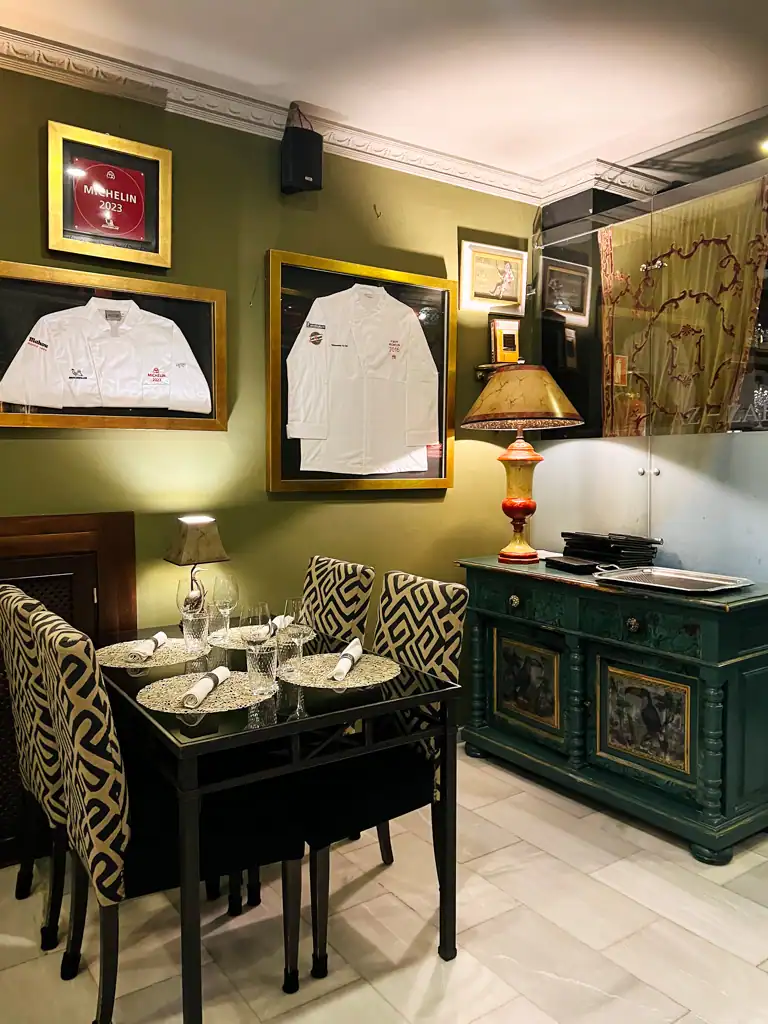 A table and Michelin jackets on the wall at Az-Zait in Seville. 