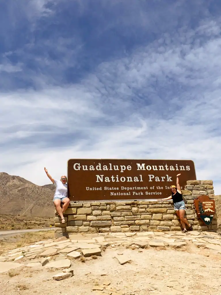 Guadalupe Mountains National Park entrance sign with two girls. 