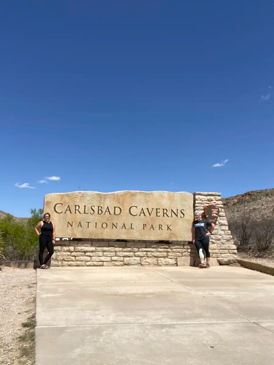 Carlsbad Caverns National Park entrance sign with two girls. 