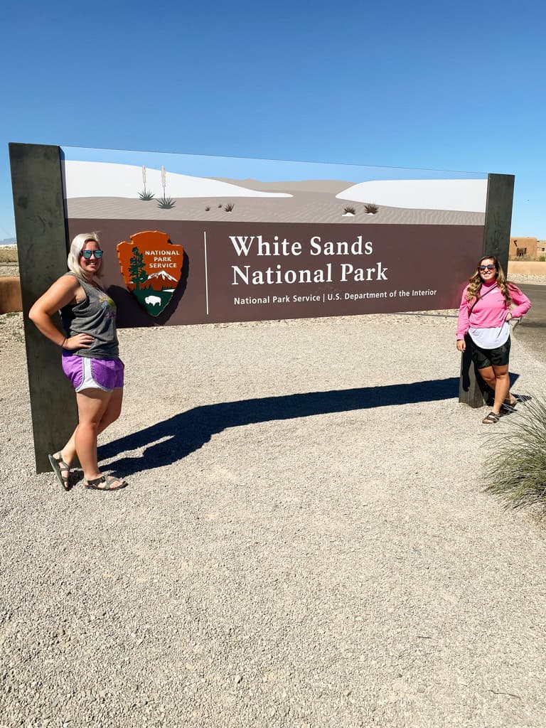 White Sands National Park entrance sign with two girls on a National Park road trip. 
