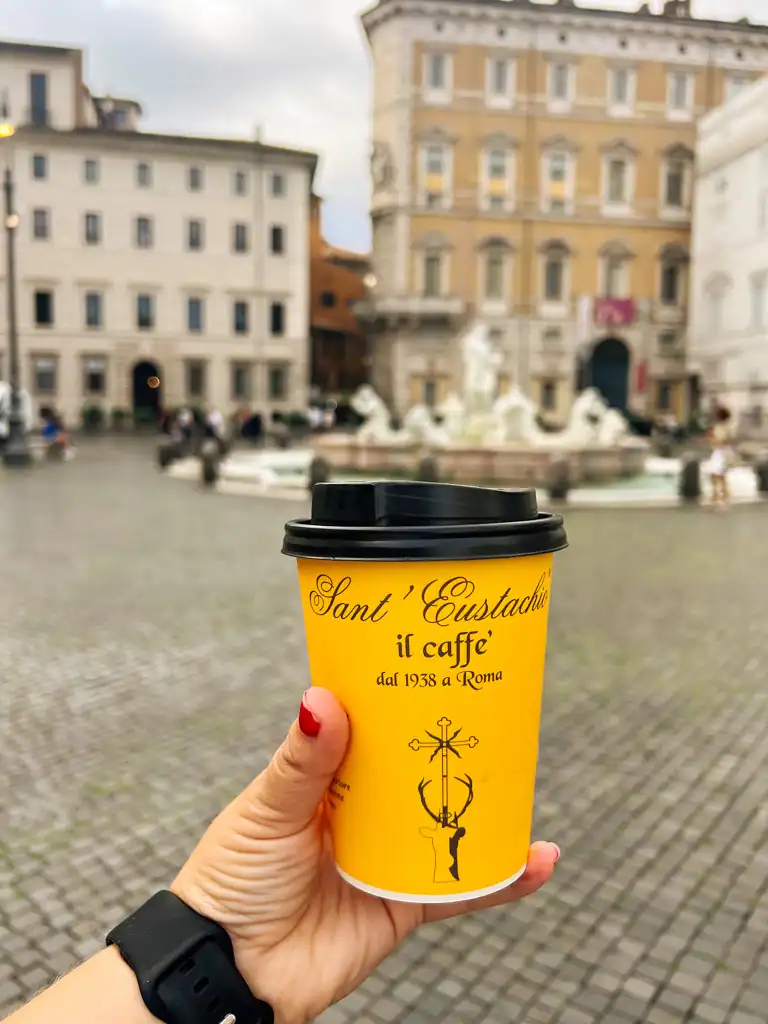 a coffee in the yellow to-go cup from Sant Eustachio cafe. 