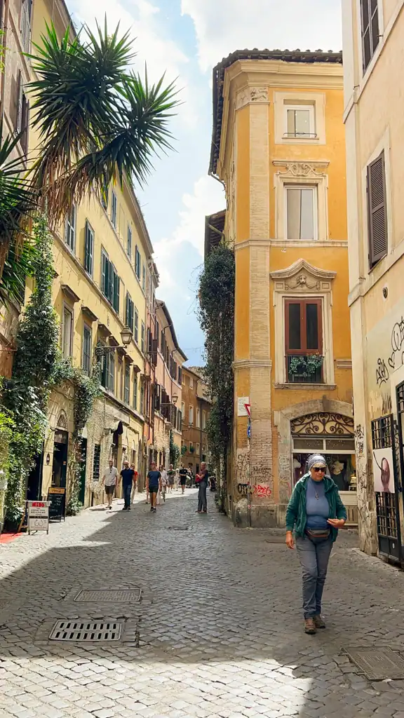 A cobblestoned street with palm trees and climbing ivy in the Monti neighborhood. 