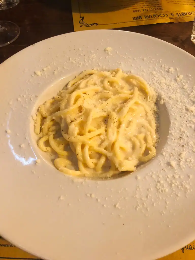 pasta in a bowl with sprinkled parmesan. 