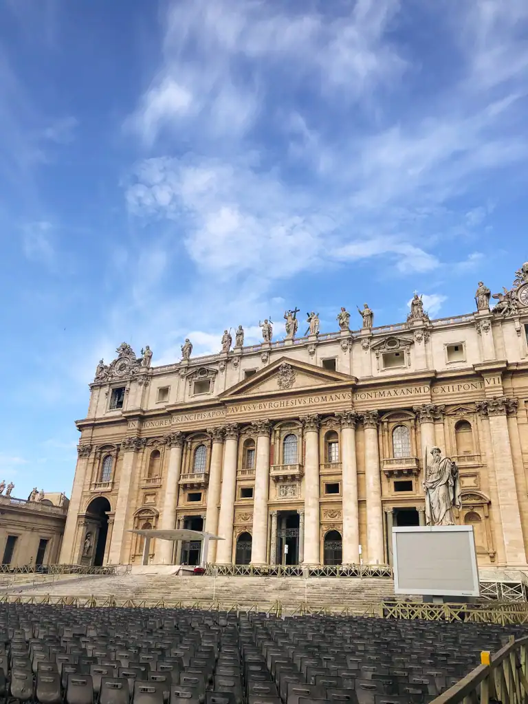 A view of St. Peter's Basilica in Rome with rows of chairs set out before the facade.