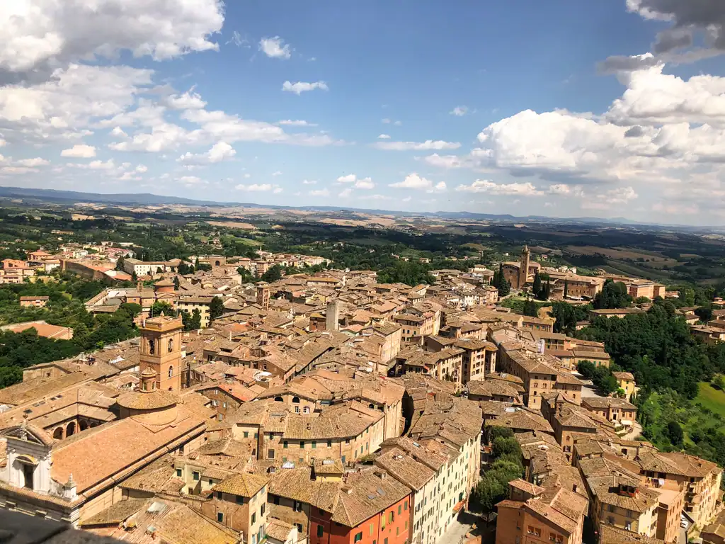 A view overlooking the brown/gold roofs and buildings in Siena in Tuscany. 