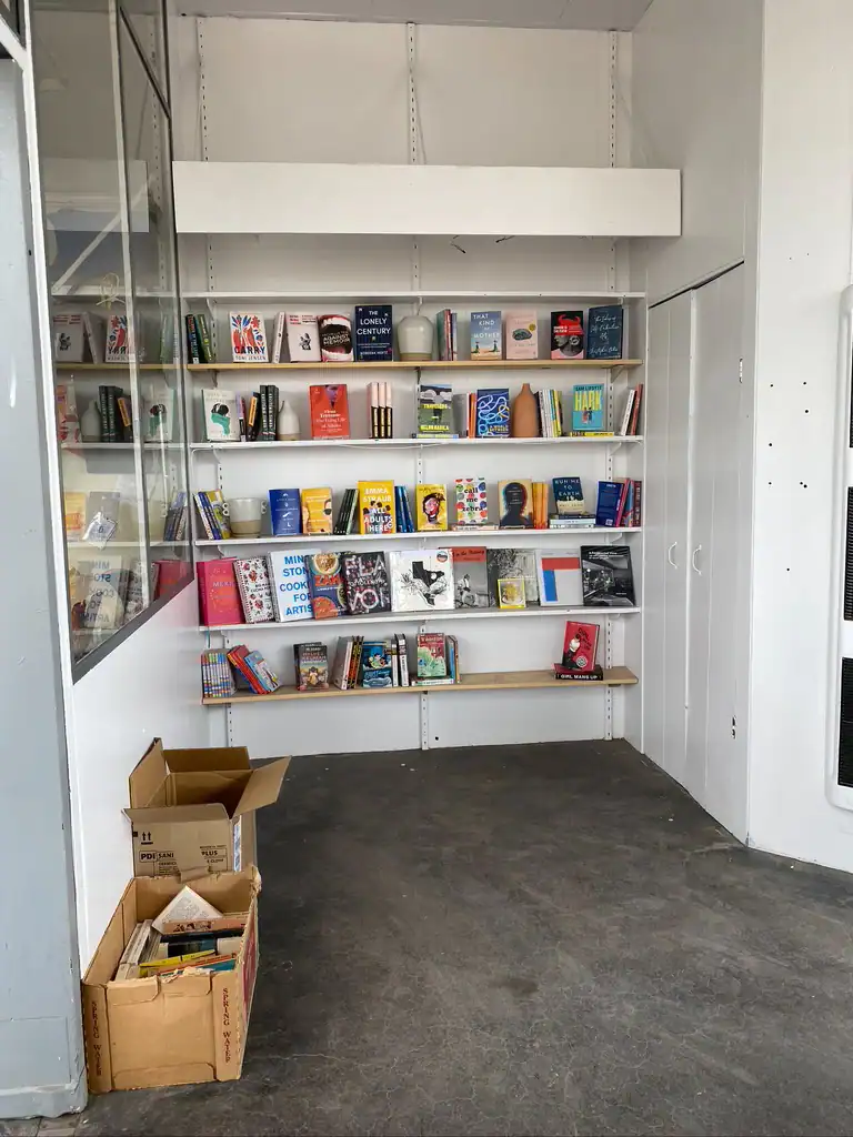A small book store with white shelves lined with books in Marfa, Texas. 