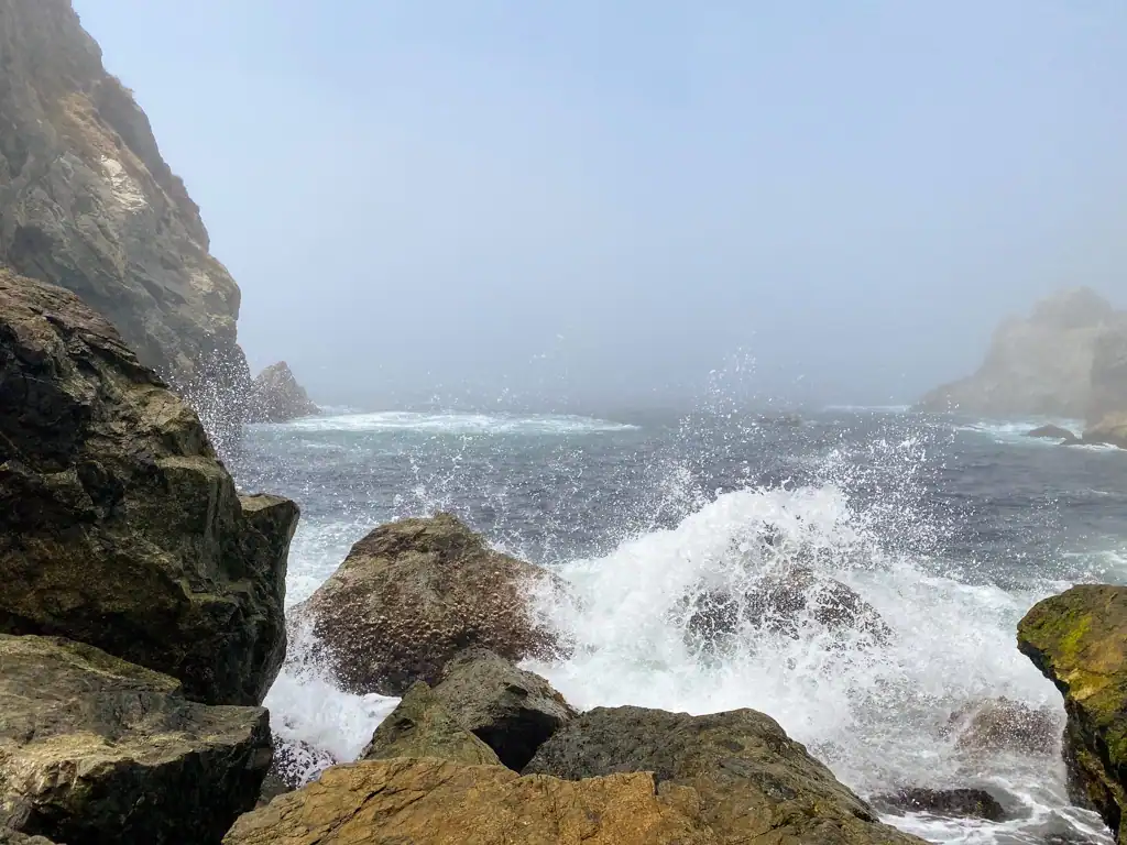 ocean water splashing on rocks in this big sur guide. 