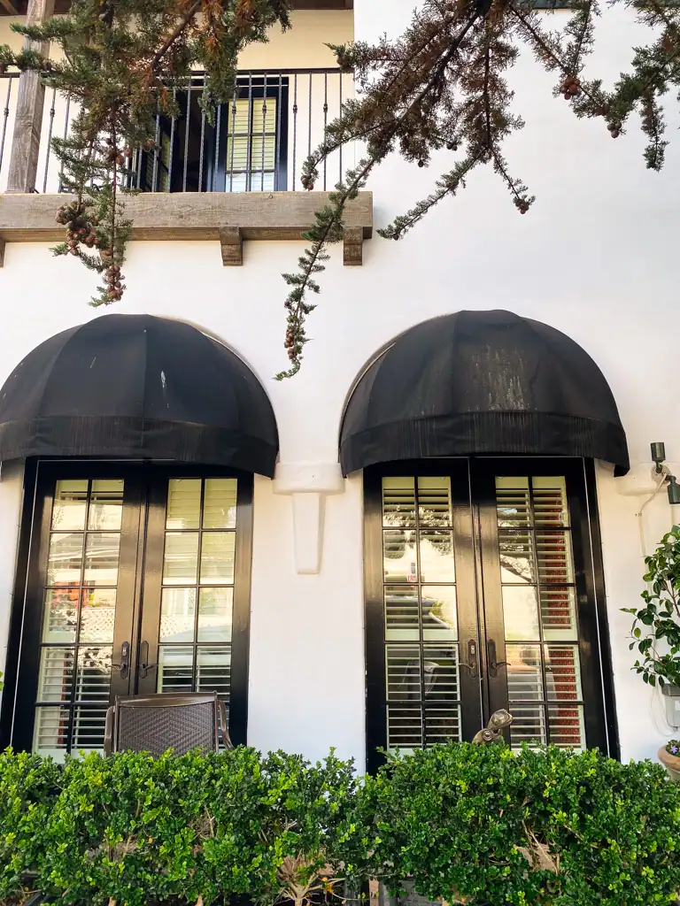 the outside of la bicyclette with two windows and 2 black awnings. 