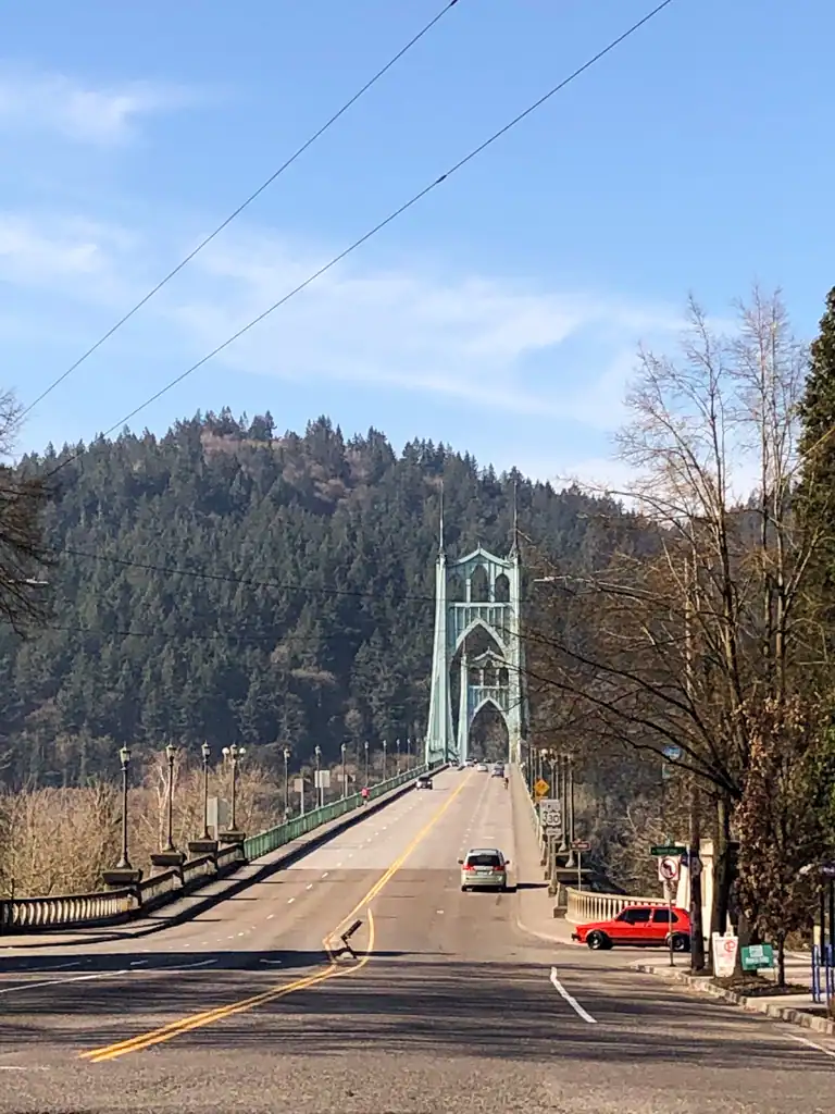 Cathedral bridge from a distance with a couple of cars driving past. 