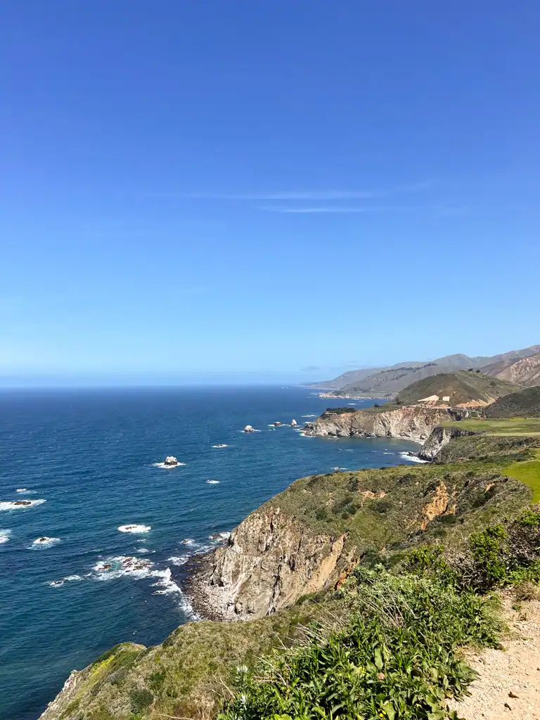 A view of the ocean and mountains and rocky outcroppings on this big sur guide. 