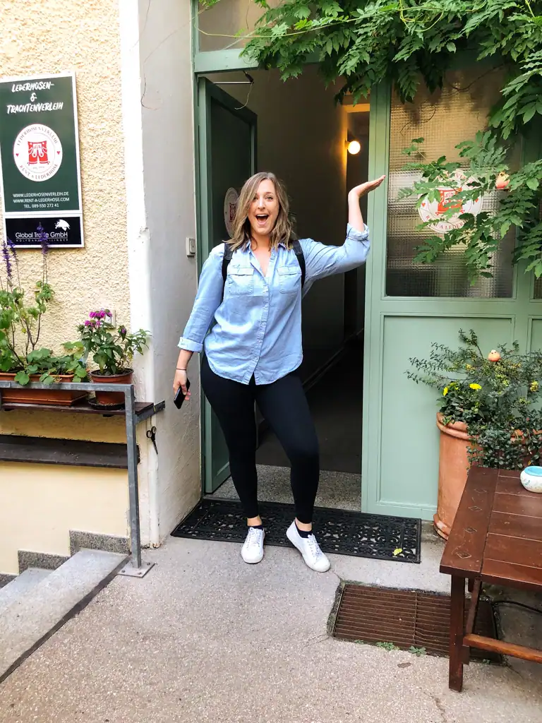 A girl in plain clothes stands outside of a shop for my essential oktoberfest guide. 
