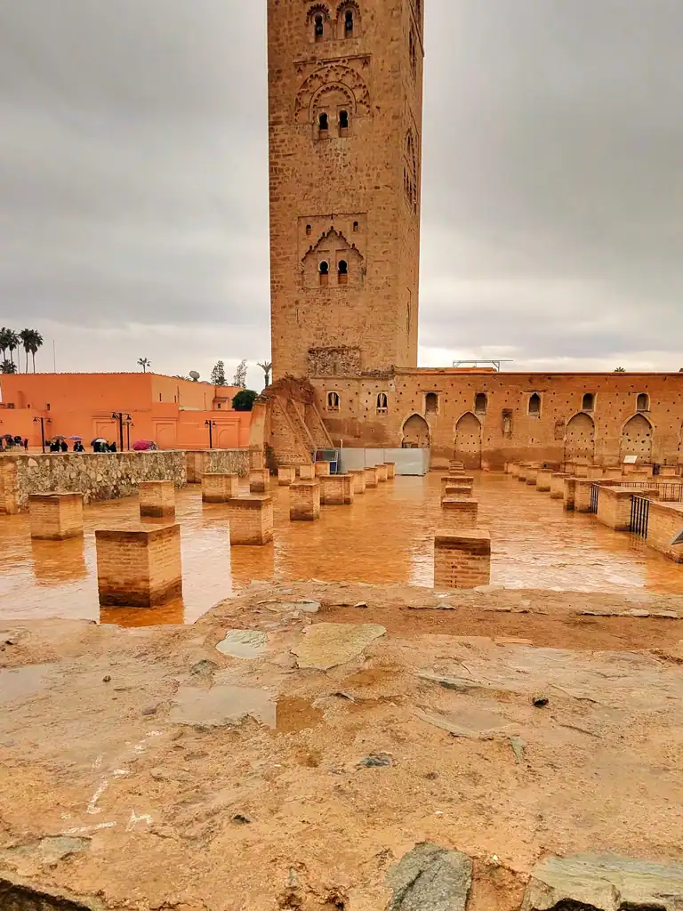 a terracotta stoned courtyard with stone blocks and the large stone mosque in the background. 