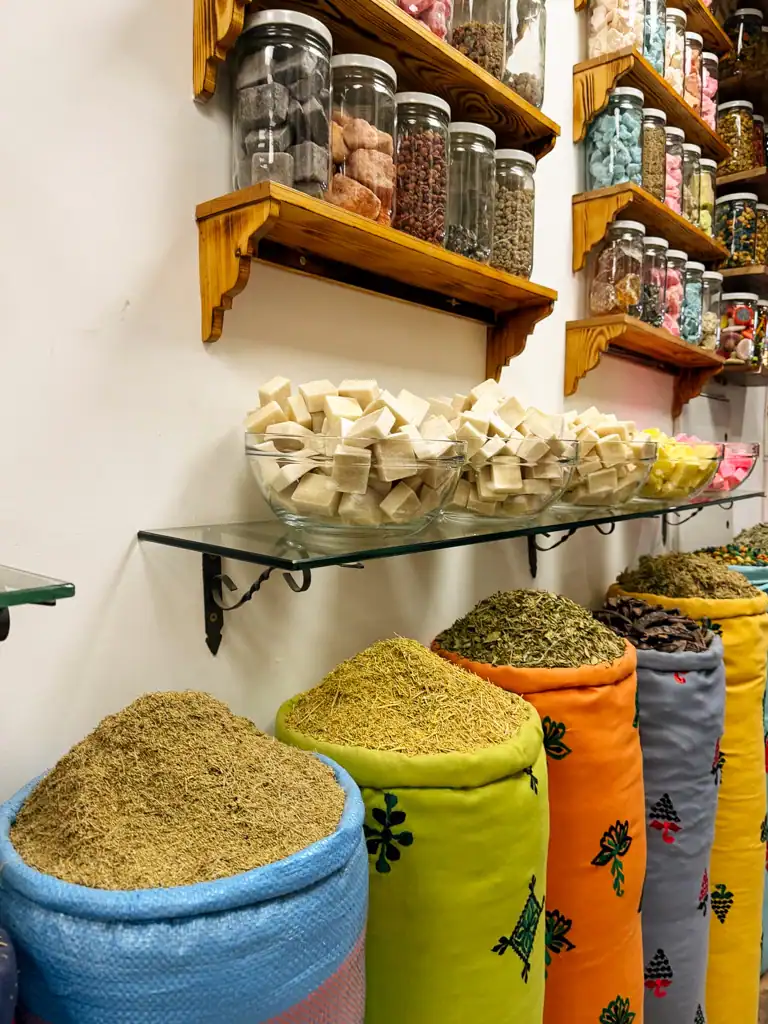 colorful bags hold mountains of spices, handmade soaps in bowls and shelves lined with other goods.
