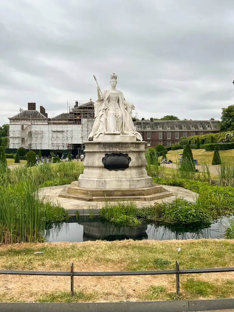 Queen victoria statue in front of kensington gardens. 