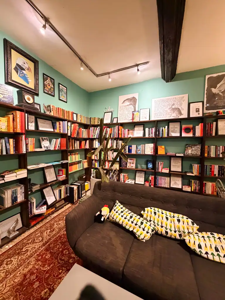 the inside of a bookstore with shelves lined with books and a couch. 