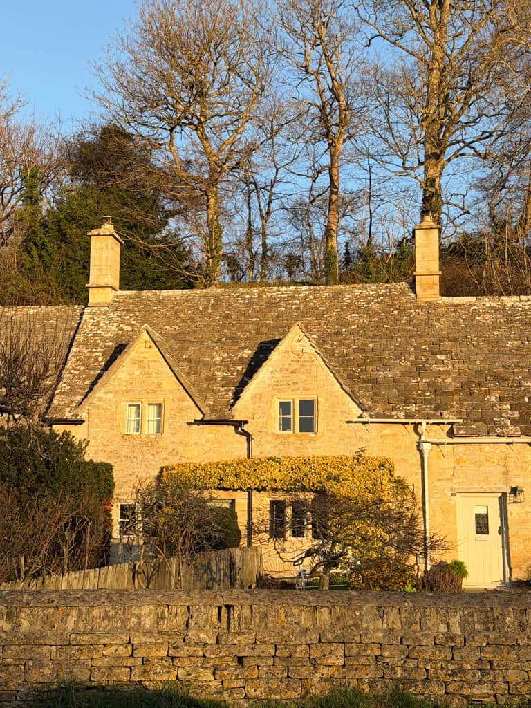 the sunset over a stone house with two chimneys. 
