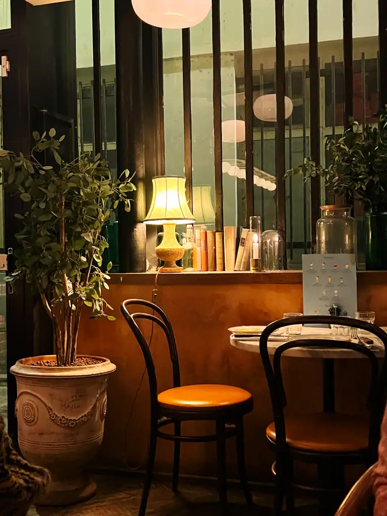 a small table and chairs in pink mamma in paris.