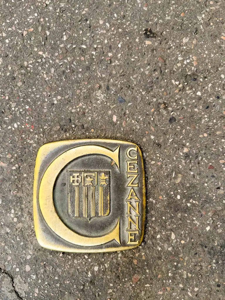 a close up of the street with the famous gold Cezanne plaque with the big C in aix-en-provence. 
