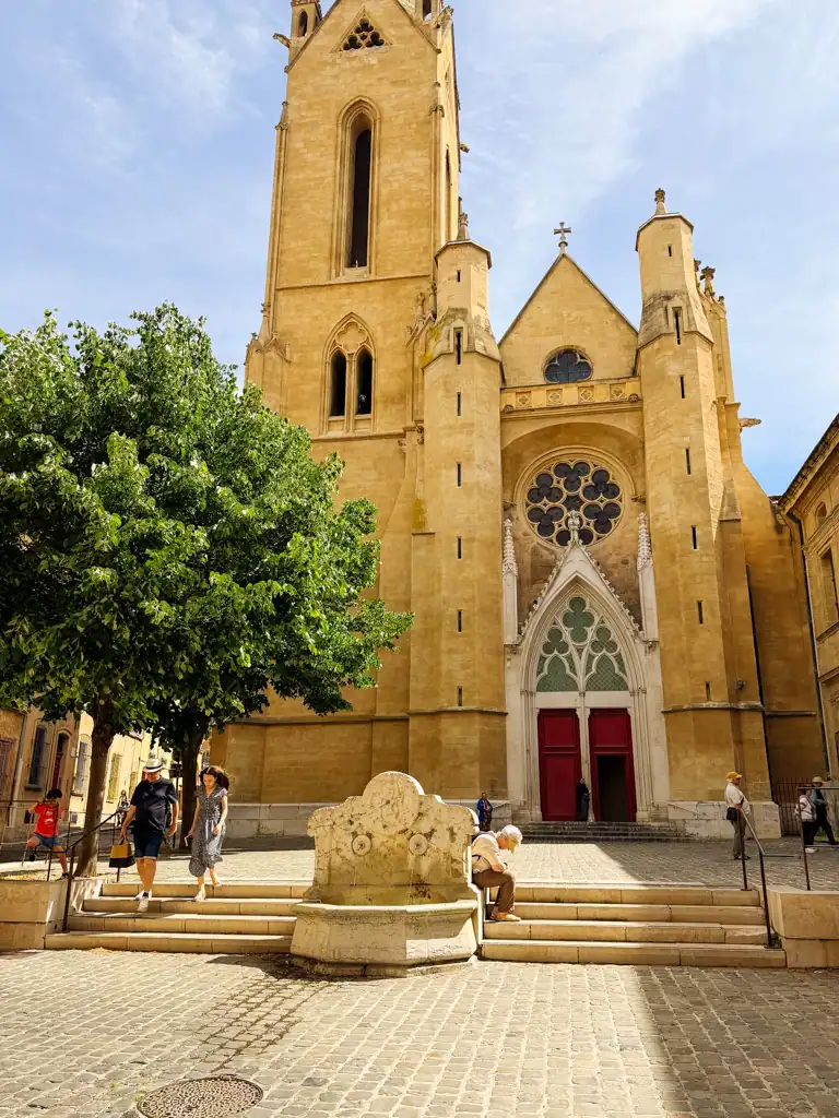 a golden church with intricate details and a fountain in aix-en-provence. 