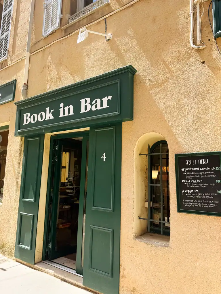 the green sign and facade of book in bar. 